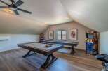 This stunning game room features a pool table, shuffleboard, and arcade game, perfect for entertaining guests.