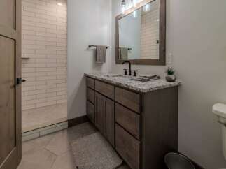 This stunning bathroom features a modern design with a beautiful vanity and a spacious shower.