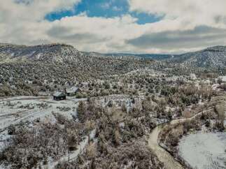 Nestled in a serene winter landscape, this property offers a unique blend of natural beauty and rustic charm.