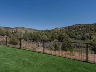 Enjoy breathtaking views from this stunning property! This home features a lush green lawn and a secure fence, perfect for relaxation and outdoor activities.