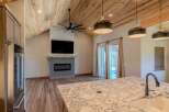 Experience modern living in this stunning home featuring a vaulted wood-paneled ceiling and a sleek fireplace as the focal point.