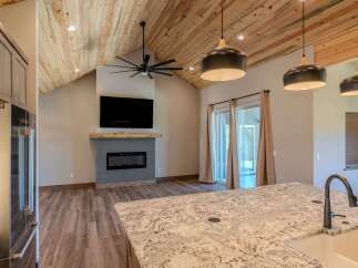 Experience modern living in this stunning home featuring a vaulted wood-paneled ceiling and a sleek fireplace as the focal point.