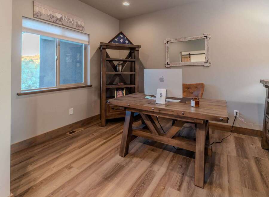 This home office features a rustic wooden desk with a modern Apple computer, perfect for productivity.