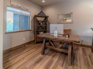 This home office features a rustic wooden desk with a modern Apple computer, perfect for productivity.