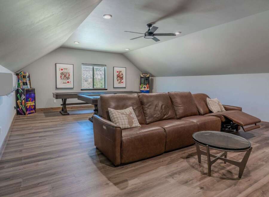 This spacious game room offers a perfect blend of entertainment and relaxation, featuring a full-size pool table and two classic arcade machines.