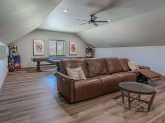 This spacious game room offers a perfect blend of entertainment and relaxation, featuring a full-size pool table and two classic arcade machines.