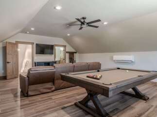 This spacious game room features a large leather sectional sofa and a classic billiards table, perfect for entertaining guests.