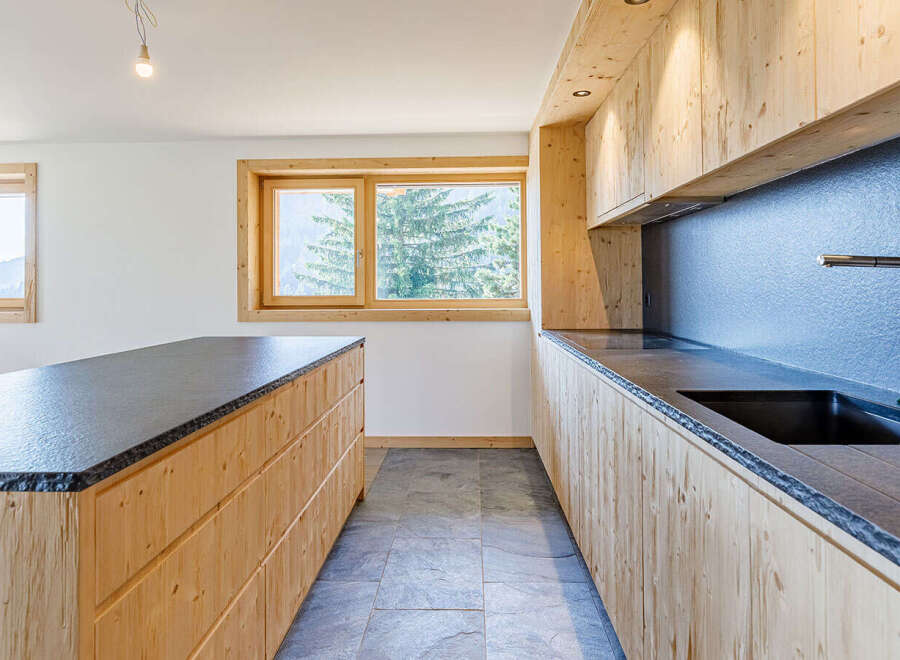 This stunning kitchen features a modern design with natural wood cabinetry and sleek countertops, creating a warm and inviting atmosphere.