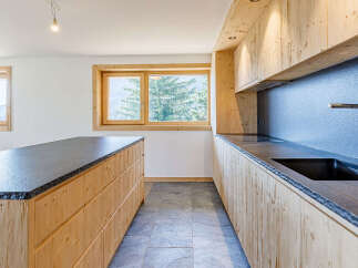 This stunning kitchen features a modern design with natural wood cabinetry and sleek countertops, creating a warm and inviting atmosphere.