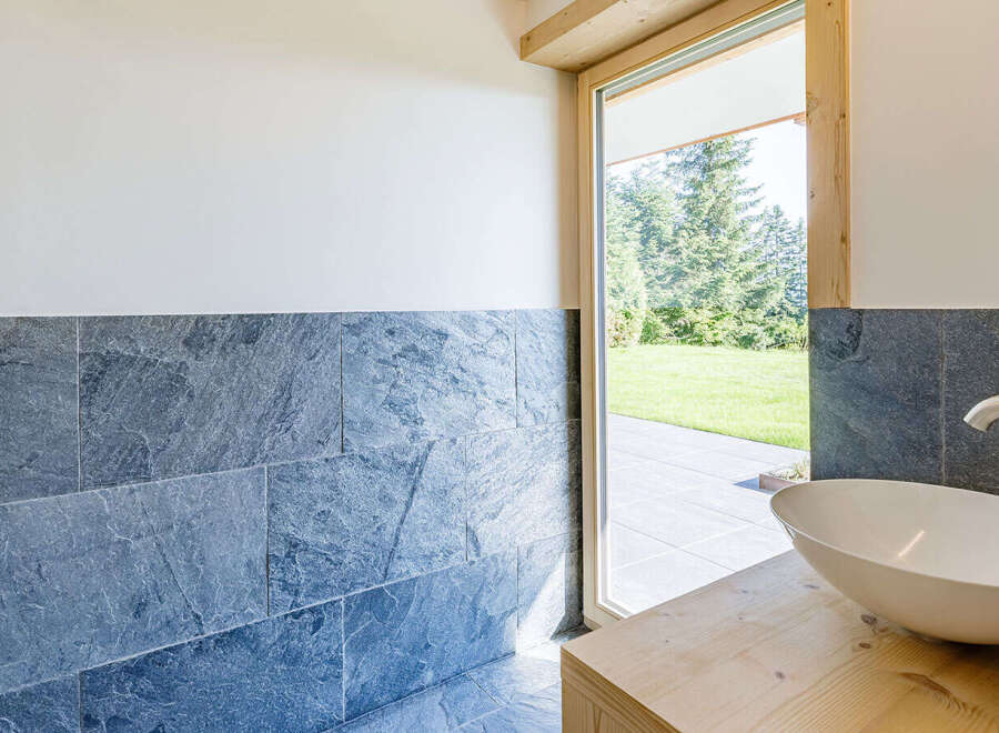This modern bathroom features a sleek, white sink set atop a natural wood vanity.