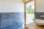 This modern bathroom features a sleek, white sink set atop a natural wood vanity.