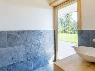 This modern bathroom features a sleek, white sink set atop a natural wood vanity.