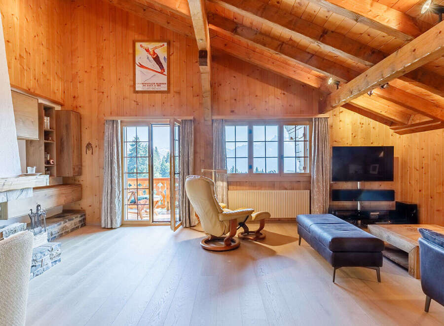 Experience the charm of this stunning chalet, featuring a cozy fireplace and exposed wooden beams that create a warm and inviting atmosphere.