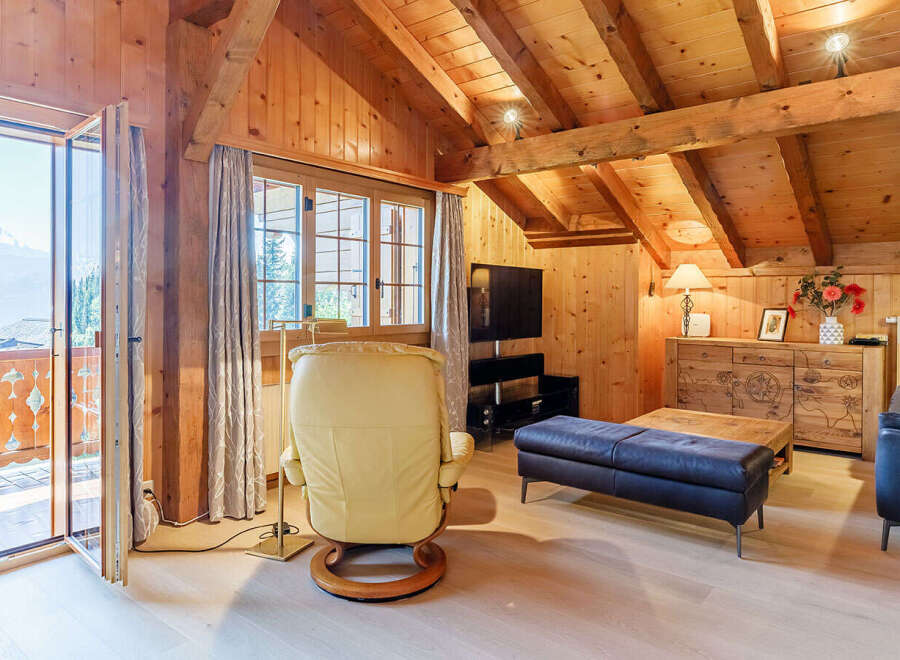 Experience the charm of this cozy chalet-style living space, featuring warm wooden accents and a vaulted ceiling.