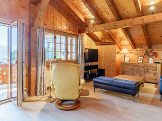 Experience the charm of this cozy chalet-style living space, featuring warm wooden accents and a vaulted ceiling.