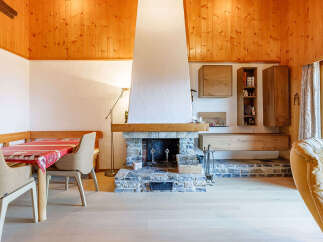 Experience the charm of this cozy living space, featuring a rustic fireplace and warm wooden accents.
