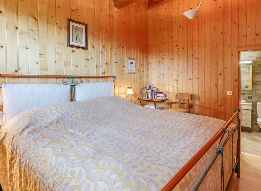 This cozy bedroom features warm wooden paneling, creating a rustic and inviting atmosphere.