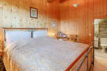 This cozy bedroom features warm wooden paneling, creating a rustic and inviting atmosphere.