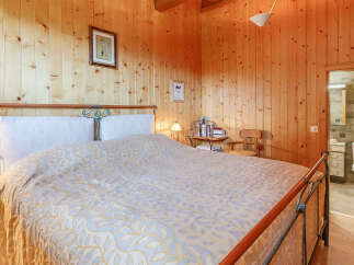 This cozy bedroom features warm wooden paneling, creating a rustic and inviting atmosphere.