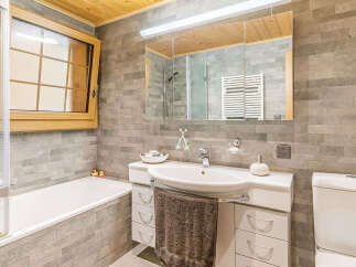 This stunning bathroom features a modern design with a sleek white sink and vanity.