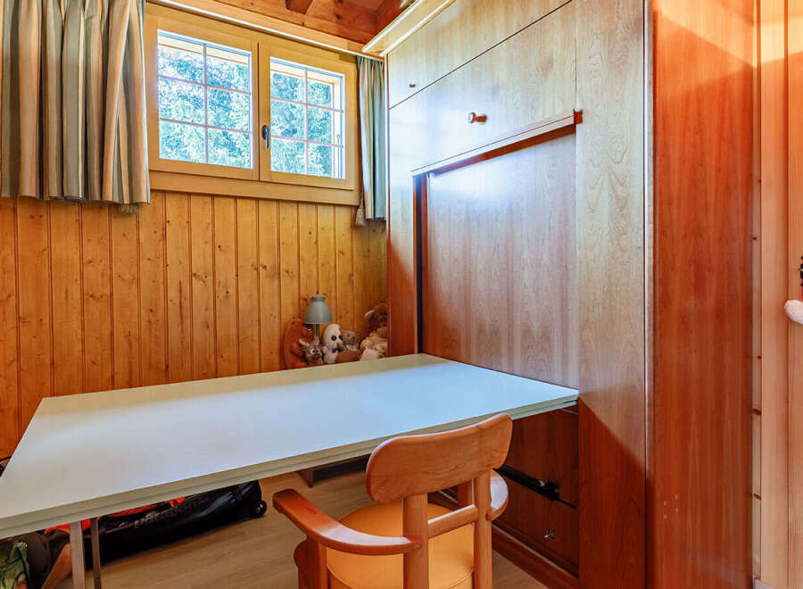 This charming room features a built-in desk and a fold-down bed, maximizing space and functionality.