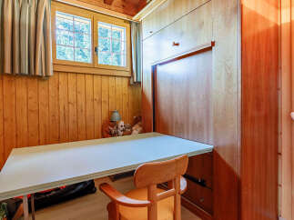 This charming room features a built-in desk and a fold-down bed, maximizing space and functionality.