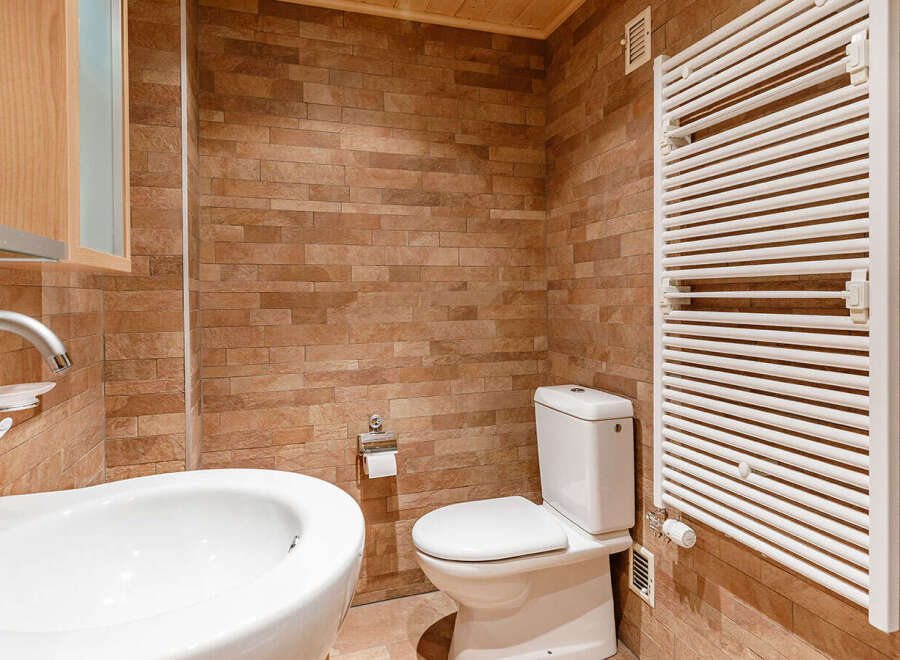This bathroom features a modern design with a sleek white sink and toilet.