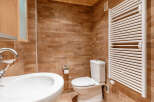 This bathroom features a modern design with a sleek white sink and toilet.