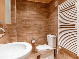 This bathroom features a modern design with a sleek white sink and toilet.