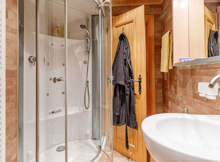 Step into this inviting bathroom, featuring a modern shower enclosure and a sleek, white sink.