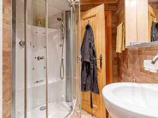Step into this inviting bathroom, featuring a modern shower enclosure and a sleek, white sink.