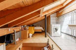 This unique loft space features exposed wooden beams and a cozy bedroom area.