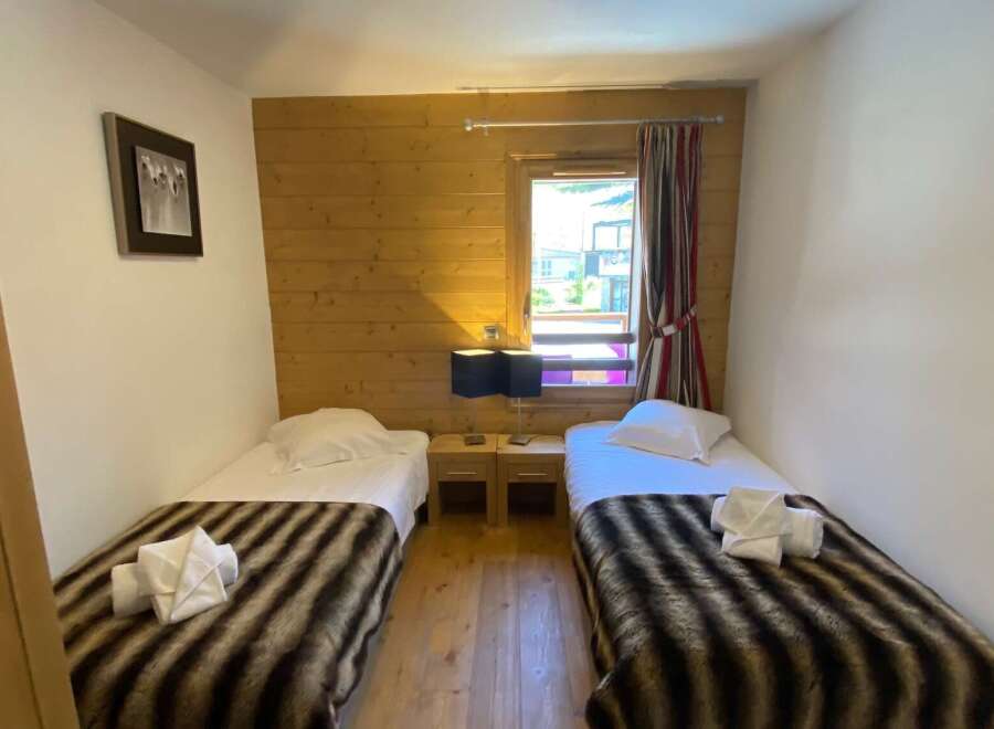 This cozy bedroom features two twin beds, perfect for a comfortable stay.