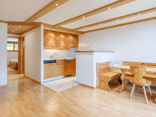 This charming property features a cozy kitchen with wooden cabinetry and a dining area with a rustic wooden table and chairs.