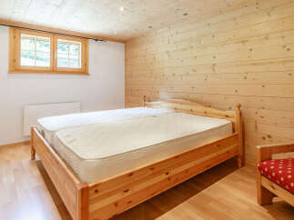 This cozy bedroom features a wooden bed frame and matching wooden paneling, creating a warm and inviting atmosphere.