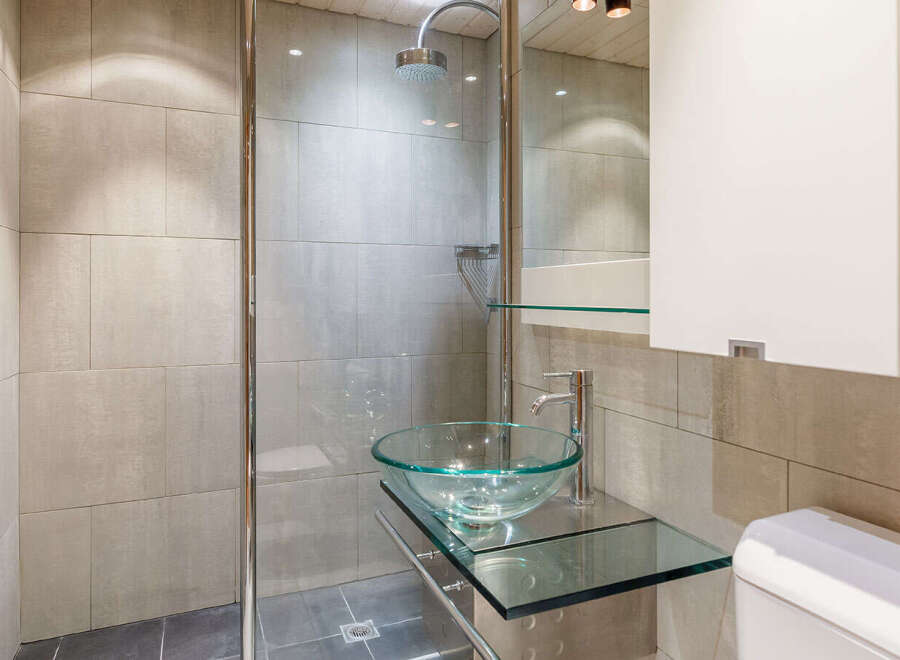 Step into a modern bathroom oasis, featuring sleek tile work and a glass-enclosed shower.