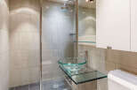 Step into a modern bathroom oasis, featuring sleek tile work and a glass-enclosed shower.