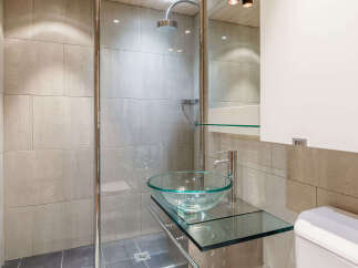 Step into a modern bathroom oasis, featuring sleek tile work and a glass-enclosed shower.