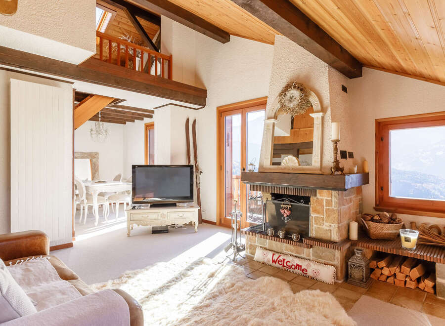 Experience the charm of this cozy living room, featuring a rustic fireplace and a warm, inviting atmosphere.