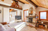 Experience the charm of this cozy living room, featuring a rustic fireplace and a warm, inviting atmosphere.