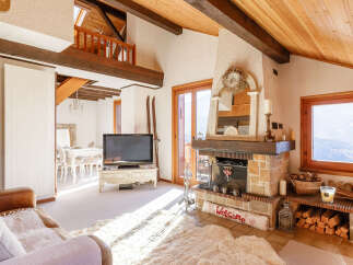 Experience the charm of this cozy living room, featuring a rustic fireplace and a warm, inviting atmosphere.
