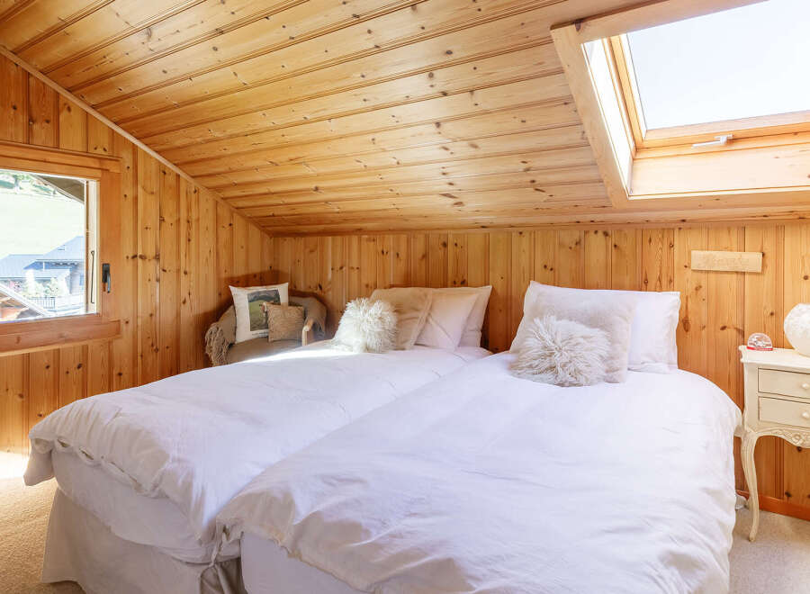 Step into this cozy bedroom featuring a charming wooden interior, creating a warm and inviting atmosphere.