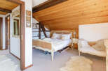 This charming bedroom features a cozy, rustic design with wooden accents and a bright, airy feel.