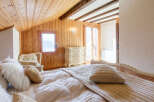 Experience the charm of this cozy bedroom, featuring a warm wooden ceiling and walls that create a serene atmosphere.