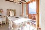 Experience the epitome of elegance in this stunning dining room, featuring a pristine white table and ornate chairs.