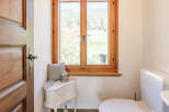 This charming bathroom features a beautiful wooden window that offers stunning views of the surrounding landscape.