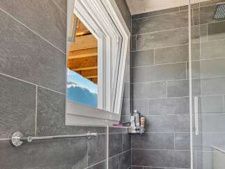 This modern bathroom features a unique design with a tilt-and-turn window, offering both ventilation and natural light.