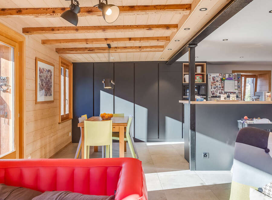 This stunning property boasts a warm and inviting interior with exposed wooden beams and paneling, creating a cozy atmosphere.