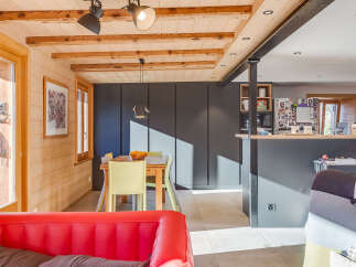 This stunning property boasts a warm and inviting interior with exposed wooden beams and paneling, creating a cozy atmosphere.