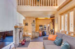 Step into this stunning chalet-style home, boasting a cozy living area with a stone fireplace and a modern TV.